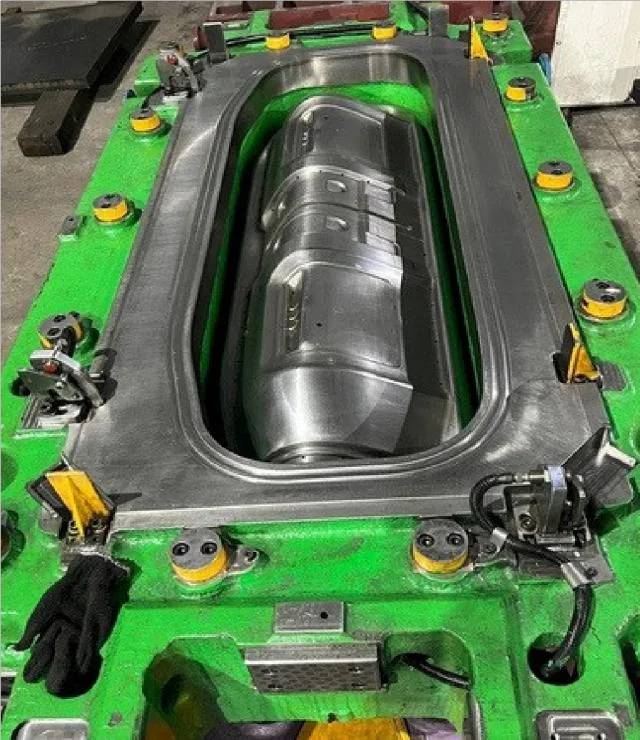 A green painted die frame with a polished oval cavity machined into its centre